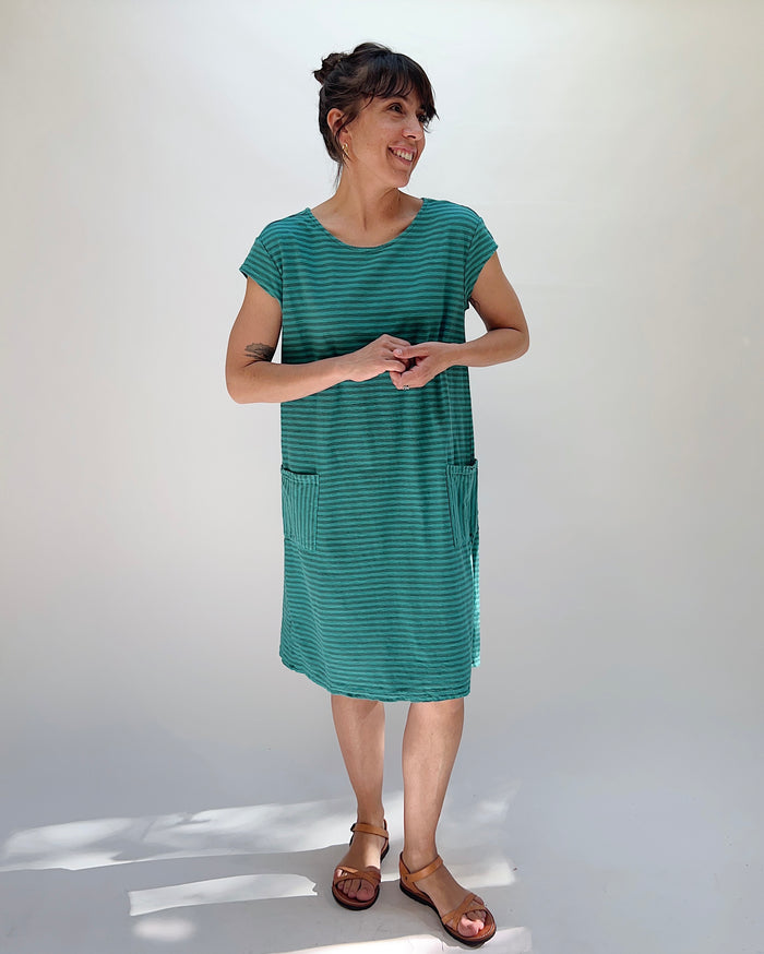Woman wearing a green striped dress against a white background