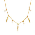 Gold necklace with fish and pearl charms on a white background