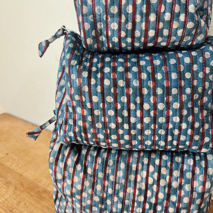 Close-up of the Toiletry Bag in Persephone Blockprint showing the slate blue quilted cotton with burgundy stripe and white polka dot block-print motif and vertical quilting stitches