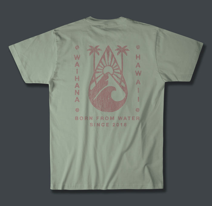 Back of a sage green Waihana Tropic Drop Premium Pima T-Shirt showing a distressed rose-pink graphic of palm trees, a surfboard, and ocean wave with 'Waihana Hawaii' and 'Born From Water Since 2018' text.