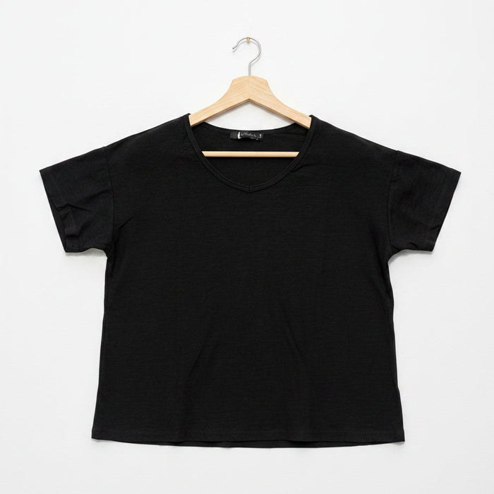 Black t-shirt on a wooden hanger against a white background