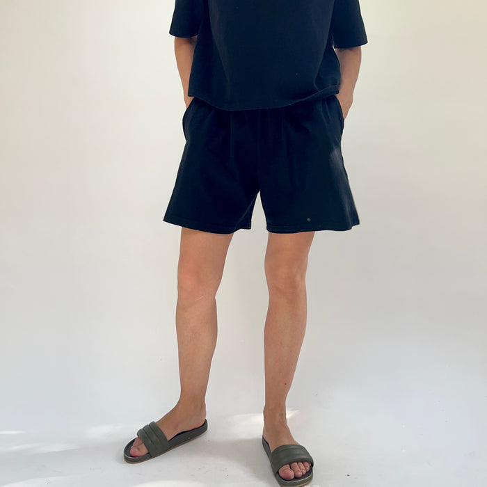 Person wearing black shorts and a t-shirt on a white background