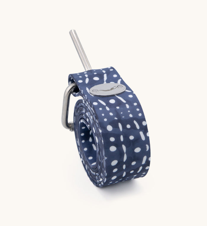 Coiled navy blue Whale Shark Dive Belt with white spot pattern, stainless steel pin buckle, and Waihana brand logo medallion on a neutral background.