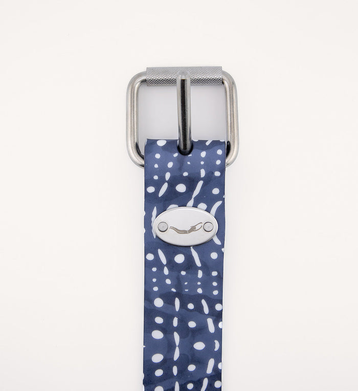 Close-up of the Whale Shark Dive Belt featuring a navy blue and white spot-pattern rubber strap with a stainless steel roller buckle and Waihana oval logo badge.