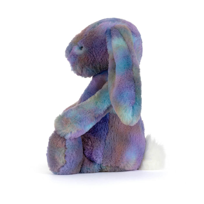 Multicolored plush bunny toy on a white background sense in profile from the side