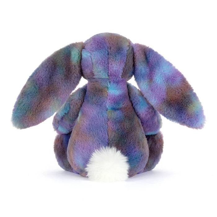 Multicolored plush bunny toy on a white background seen from behind